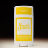 Solid serum deodorant stick with yellow and white label on a black background